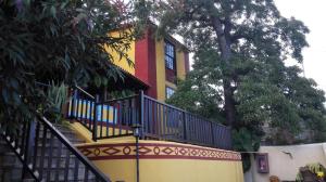 ein gelbes und rotes Gebäude mit einer Treppe vorne in der Unterkunft Hotel Rural La Raya 1866 in Güímar