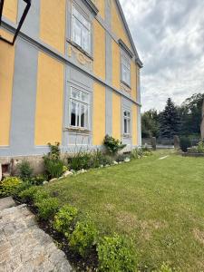 a yellow and gray house with a yard at CG Haensch in Großschönau