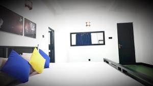 a bedroom with a bed with blue and yellow pillows at SummerSet in Dambulla