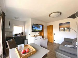 a living room with a table with a bowl of fruit on it at Süderhaus Hiddensee App 5 in Neuendorf