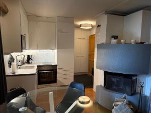 een keuken met een glazen tafel en een open haard bij Rukankieppi in Ruka