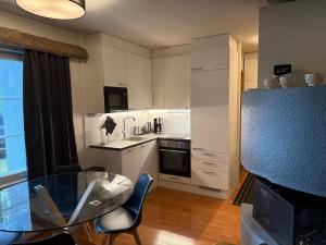 een kleine keuken met een glazen tafel en stoelen bij Rukankieppi in Ruka +8 foto's