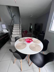 a white table and chairs in a room with stairs at Duplex premium com garagem perto do centro 5 hósp. in Garanhuns