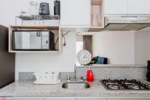 a kitchen counter with a sink and a microwave at 3BR Pool & Gyw in Lima