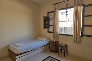 a small bedroom with a bed and a window at Acesso a Praia com Área Gourmet in Saquarema