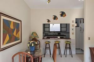 a kitchen with a glass table and stools at Acesso a Praia com Área Gourmet in Saquarema