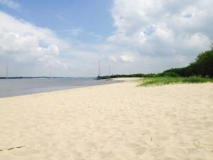 a sandy beach with the ocean in the background at Ferienhaus Deichgraf 65 im Feriend in Hollern-Twielenfleth