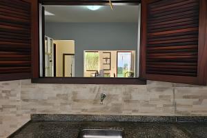 a bathroom with a sink and a mirror at Acesso a Praia com Área Gourmet in Saquarema +29 photos