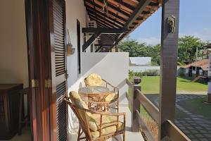 a balcony with two chairs and a table on a house at Acesso a Praia com Área Gourmet in Saquarema