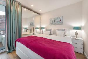a bedroom with a large bed with a red blanket at Kleine Lagune in Zingst +5 photos