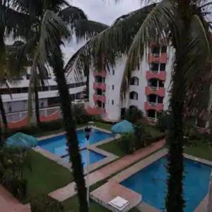 a hotel with palm trees in front of a building at Depa Santorini in Veracruz
