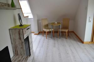 a living room with a fireplace and a table and chairs at Ferienwohnung mit Terrasse und in Seenähe in Krakow am See
