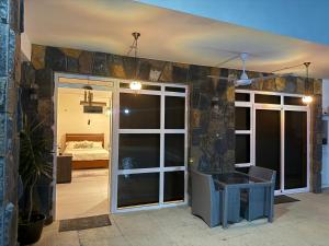 a room with a stone wall with a table and a bed at L'Éveil du Lotus in Grand-Baie