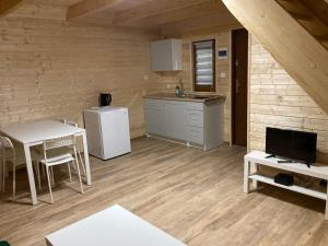 a kitchen with a refrigerator and a table in a room at Agroturystyka i Domki Zacisze in Jarosławiec
