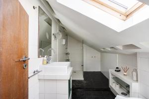 bagno con lavandino bianco e lucernario di Home Out Casa do Arco in Belém a Lisbona Altre 43 foto