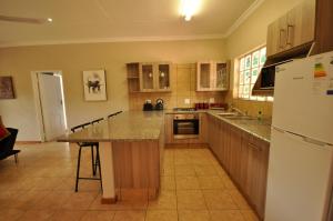 a kitchen with a refrigerator and a counter top at Eden Cottage in White River