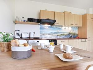 - une cuisine avec une table en bois et de la nourriture dans l'établissement Residenz Haffblick, Wohnung 37, à Boltenhagen 20 autres photos