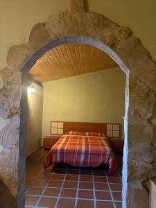 a bedroom with a bed in a stone wall at Charming Farmhouse in Enguera, Spain with Private Pool and Mountain Views in Enguera