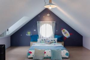 a bedroom with a bed with a rocket themed wall at Star Moon Attic in Magong