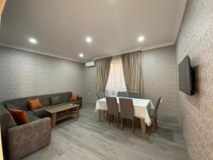 a living room with a couch and a table and chairs at Twin villas VSL in Gabala