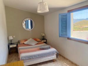 a bedroom with two beds and a window at Mojacar farmhouse apartments with pool in Los Gallardos +26 photos