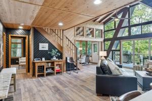 un soggiorno con divano nero e soffitti in legno di Innsbrook Lakeside Chalet a Innsbrook