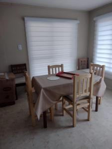 a dining room with a table and chairs and a window at Cabaña 4 Brisas del Valle in Tafí del Valle +28 photos