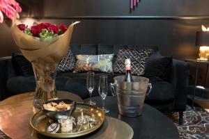 un tavolo con un vaso di fiori e una bottiglia di vino di L'inattendu - Loveroom chic et spacieuse avec jacuzzi a Le Havre