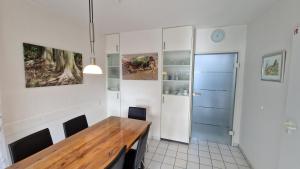 a dining room with a wooden table and a blue door at Nr 97 - Ferienhaus Uferstraße in Carolinensiel +14 photos