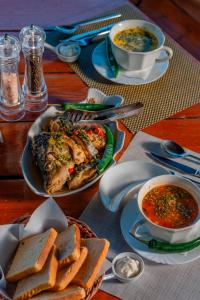a table with a plate of food and a bowl of soup at Pensiunea Ovidiu in Crisan