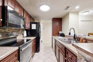 フェルナンディーナ・ビーチにあるGround-floor summer beach village condo with a great view plus patio & poolのシンクと冷蔵庫付きのキッチン