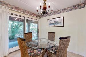 フェルナンディーナ・ビーチにあるGround-floor summer beach village condo with a great view plus patio & poolのガラスのテーブルと椅子のあるダイニングルーム