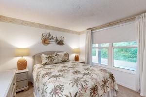 フェルナンディーナ・ビーチにあるGround-floor summer beach village condo with a great view plus patio & poolのベッドと大きな窓のある寝室