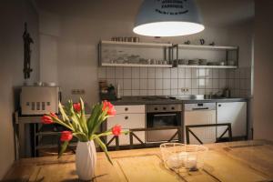 a kitchen with a table with a vase of flowers at Kölp - Wald und Mee h r in Kölpinsee +47 photos