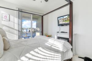 a bedroom with a white bed and a television at 3 Mi to Main St Tracy Homey Retreat with Game Room! in Tracy