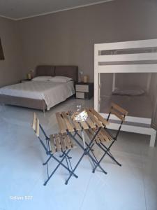 2 sillas y 1 mesa en un dormitorio con 1 cama en B&B Al gafio da Aurora, en Corigliano Calabro