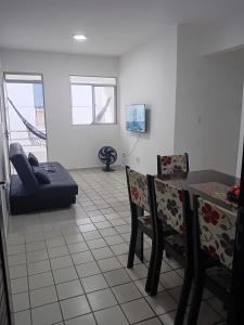 een woonkamer met een tafel, stoelen en een bank bij Apt amplo 3 quartos Manaíra in João Pessoa