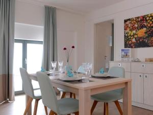 a dining room with a wooden table and chairs at Ohlerich Speicher App_ 40 in Wismar