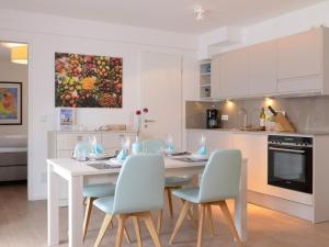 a white kitchen with a white table and chairs at Ohlerich Speicher App_ 40 in Wismar