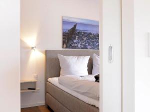 a bedroom with a bed with a cat laying on it at Ohlerich Speicher App_ 40 in Wismar