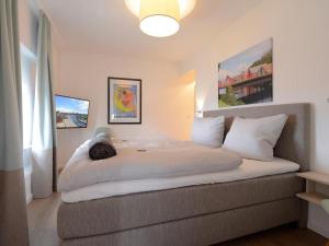 a bedroom with a bed with a cat laying on it at Ohlerich Speicher App_ 40 in Wismar +16 photos