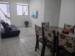 een woonkamer met een tafel, stoelen en een bank bij Apt amplo 3 quartos Manaíra in João Pessoa