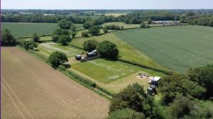 an aerial view of a field with a farm at Get Away Hide Away in East Dereham