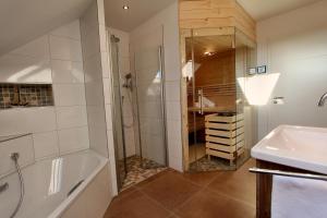 Un baño con ducha, bañera y lavabo. en Ferien_VILLA BENVENUTI, en Göhren-Lebbin 8 fotos más
