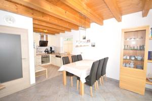 a kitchen and dining room with a table and chairs at Nr 52 - Ferienhaus Marie-Ulfers-Weg in Carolinensiel +15 photos