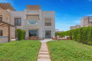 Banī GhālibにあるLagoonfront 3BR Apartment Cyanの芝生の広い白い家