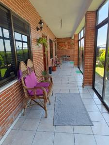 a porch with two chairs and a brick wall at Casa cómoda, amplia y tranquila in La Pedraja de Portillo