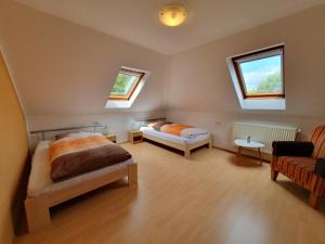 a bedroom with two beds and a couch and two windows at Ferienobjekte Claus, 35633 in Uplengen