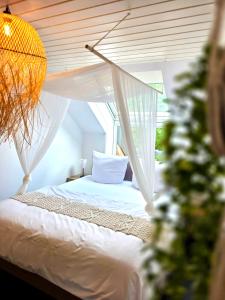 a bedroom with a white bed with a canopy at Residenz Cheval - BOHO - Ravensburg - Bodensee in Ravensburg