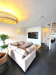 a living room with a couch and a staircase at Residenz Cheval - BOHO - Ravensburg - Bodensee in Ravensburg